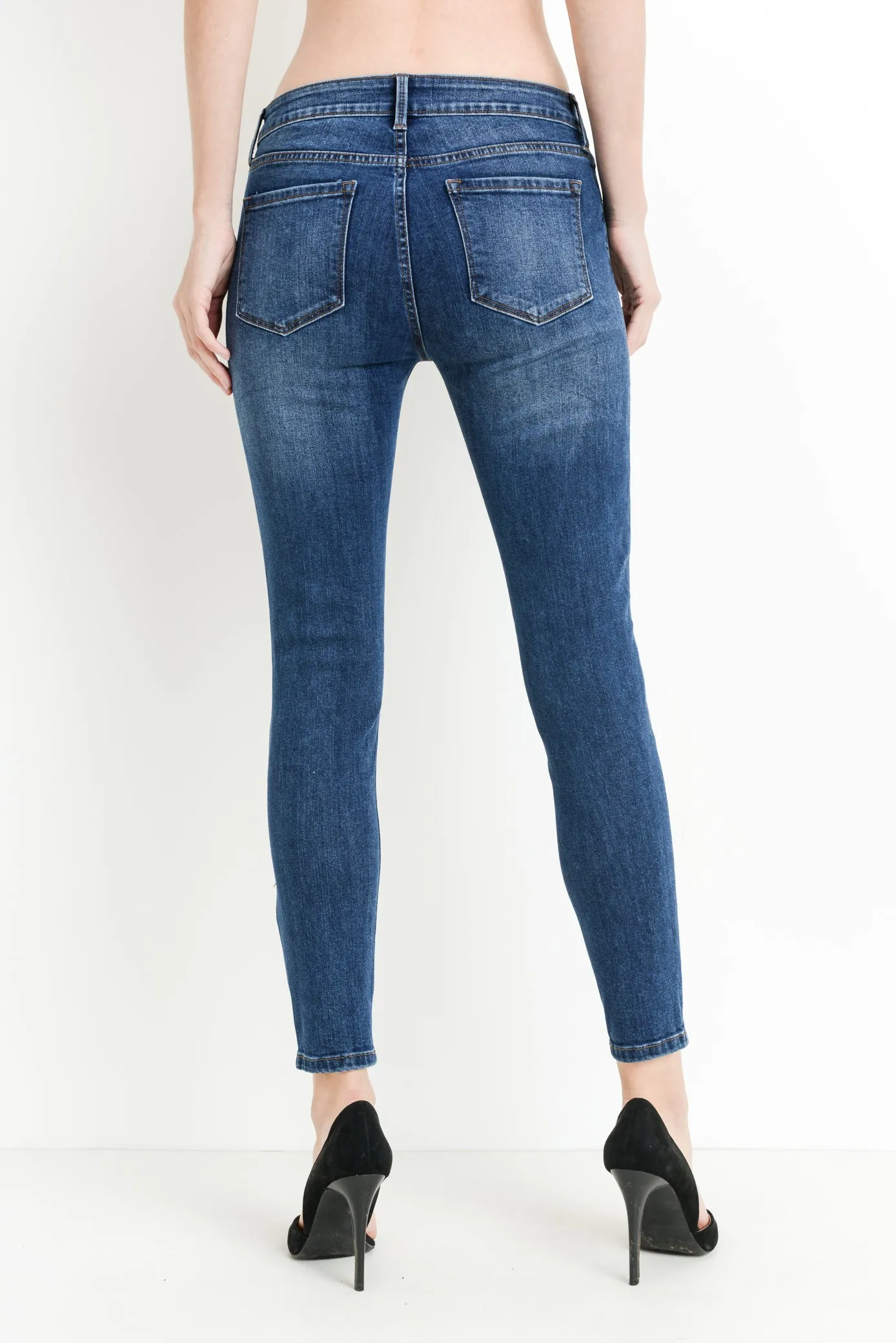 Mid rise dark denim skinny jeans with distressing